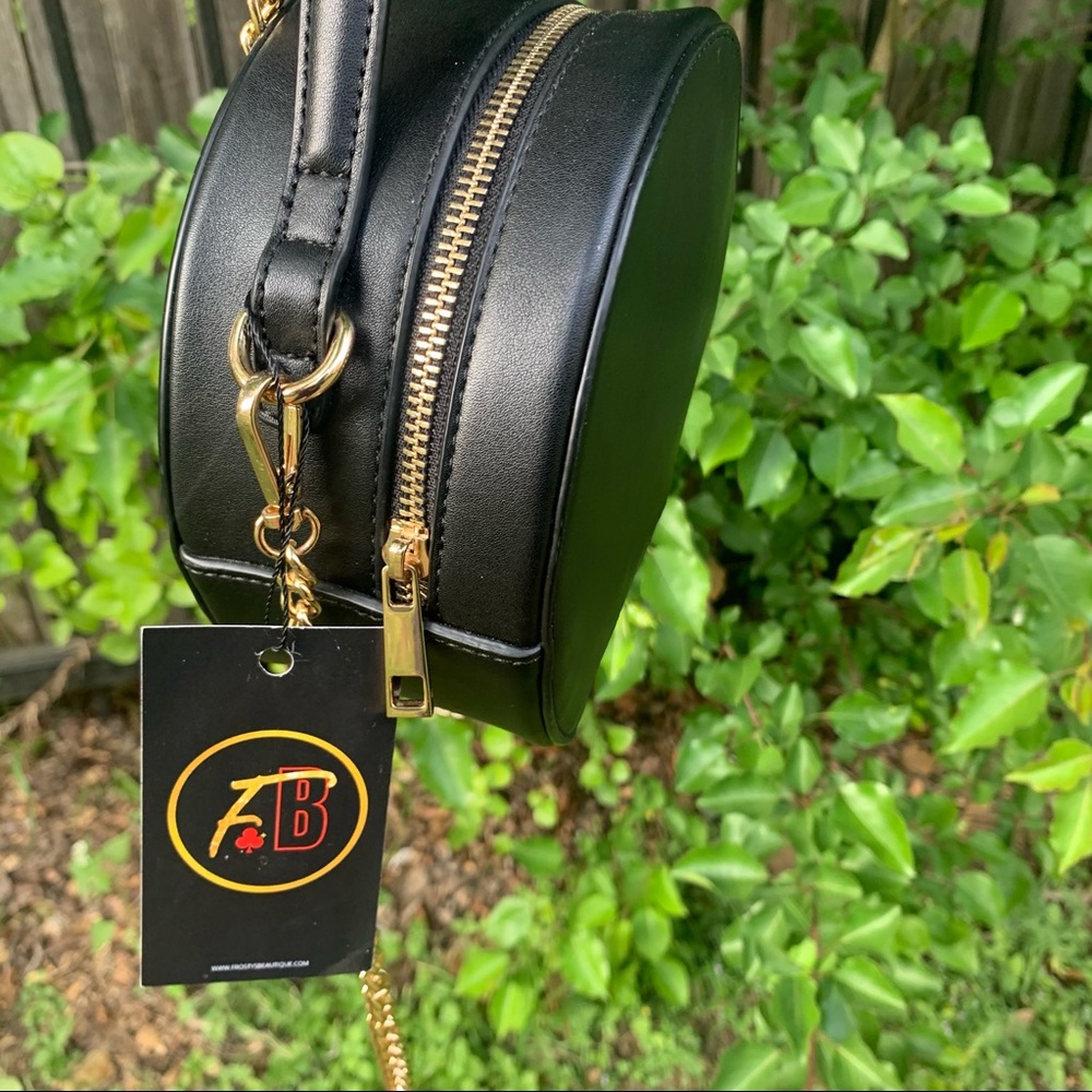 Black round purse with gold chained strap